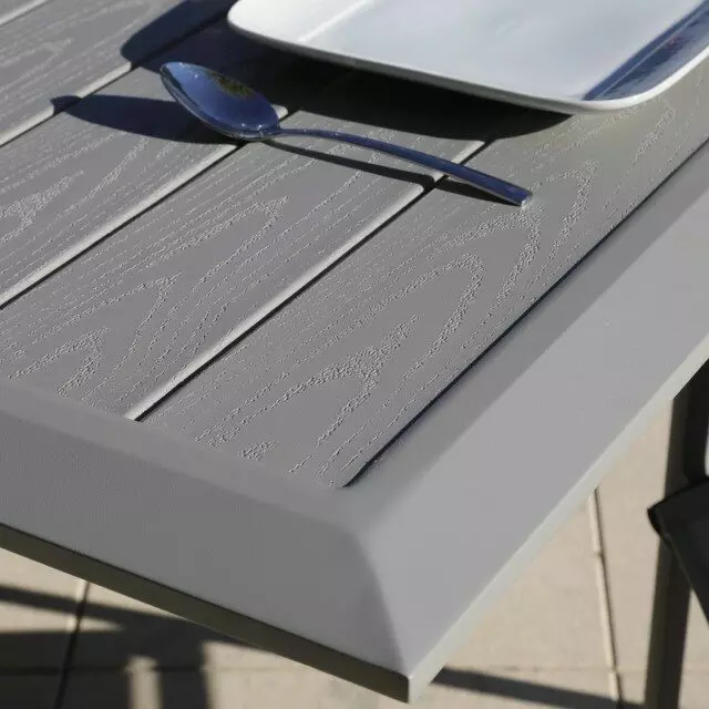 L'image présente une superbe table en aluminium de la gamme Arano, affichant un design moderne et élégant. La surface de la table est parfaitement lisse, reflétant la lumière ambiante de manière subtile.