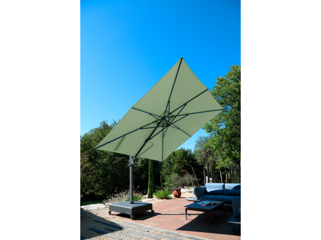 Parasol déporté - Centaurus Vert Amande. Parasol Premium anti-UV – Vert Amande (3.5×3.5) la structure est renforcée avec un mât 75x100mm et 2.2mm d’épaisseur. Cette structure “super strong” permet suivant les calculs du département R&D une inclinaison de seulement 3°. C’est un parasol déporté et anti-UV.