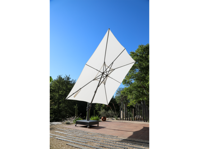 Toile déployée du parasol Premium anti-UV – Vega Blanc Natural 3,5x3,5. La structure est renforcée avec un mât 75x100mm et 2.2mm d’épaisseur. Cette structure “super strong” permet suivant les calculs du département R&D une inclinaison de seulement 3°. C’est un parasol déporté et anti-UV.