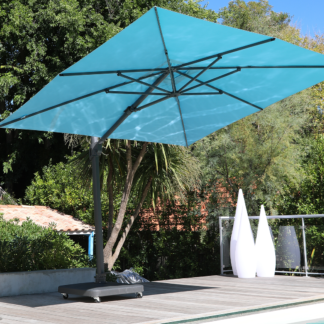 Parasol déporté - Centaurus Bleu Minéral. Parasol Premium anti-UV – Bleu (3.5×3.5) la structure est renforcée avec un mât 75x100mm et 2.2mm d’épaisseur. Cette structure “super strong” permet suivant les calculs du département R&D une inclinaison de seulement 3°. C’est un parasol déporté et anti-UV.