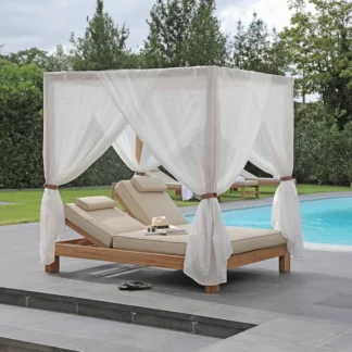 Photo du lit double de piscine à baldaquin en Teck avec coussin polyester près d'une piscine.
